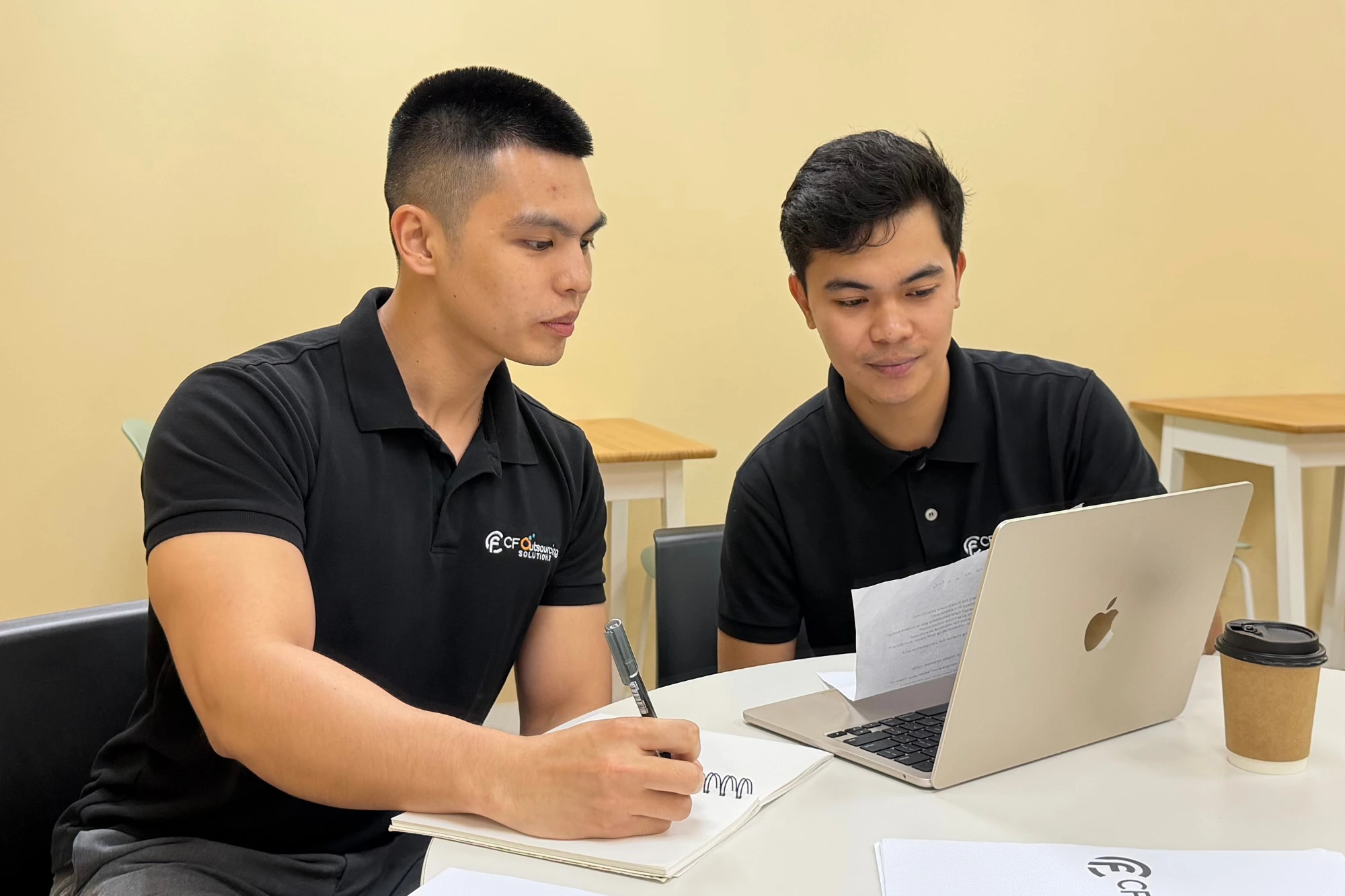 A CF team member guiding a colleague through work at a computer